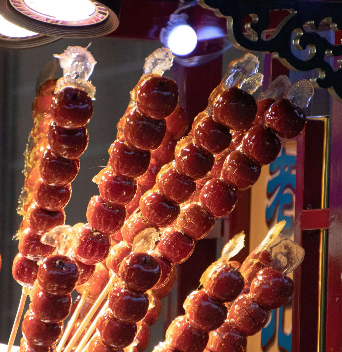 Rows of candied hawthorn glowing under a market light